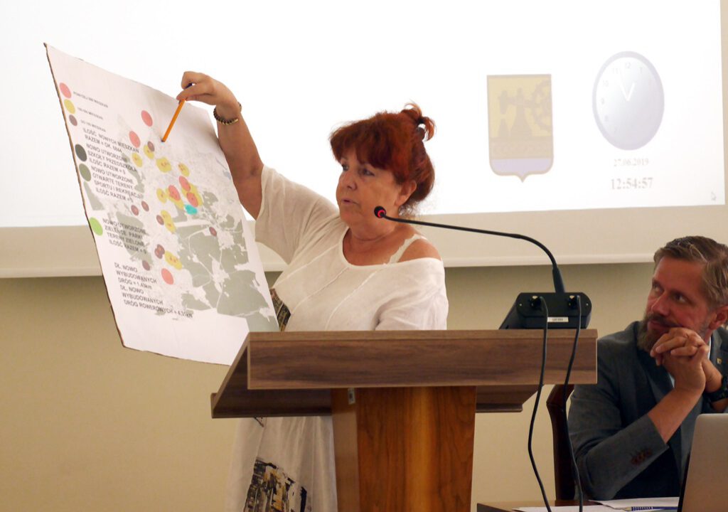Grażyna Szczurkowska z mapą planowanych lub trwających inwestycji mieszkaniowych.